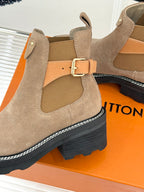 Beige suede ankle boot close-up with buckle strap and padded inner lining