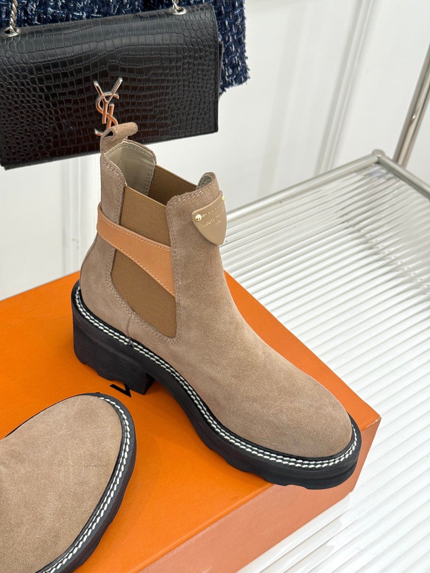 Beige suede ankle boot with side elastic panels and buckle strap on platform sole