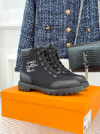 Black mid-top lace-up boot with thick rubber sole and round toe