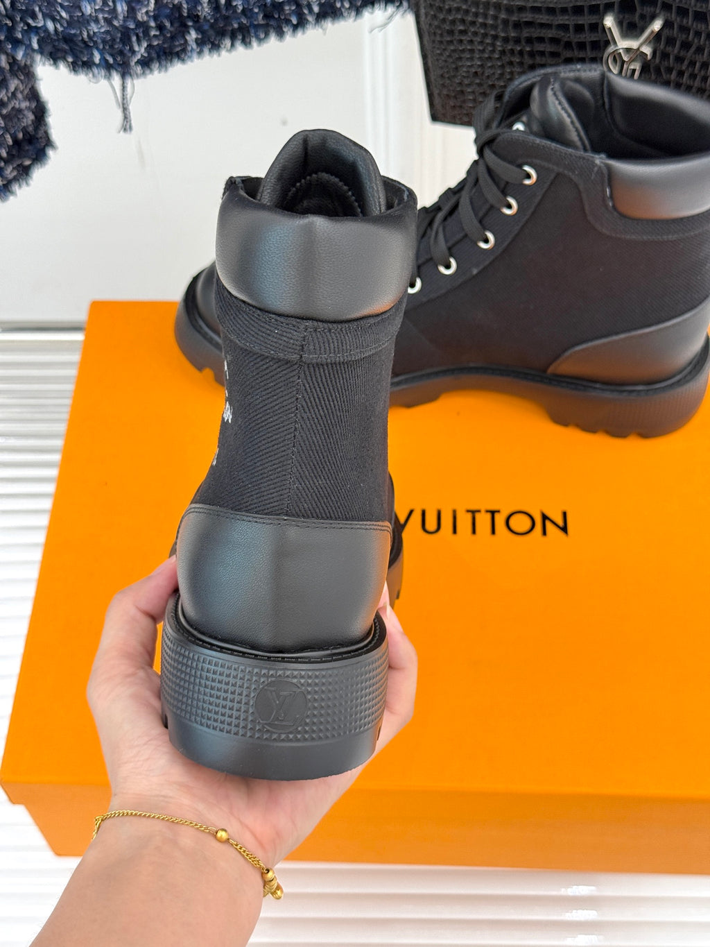 Black mid-top lace-up boot back view with thick grippy outsole
