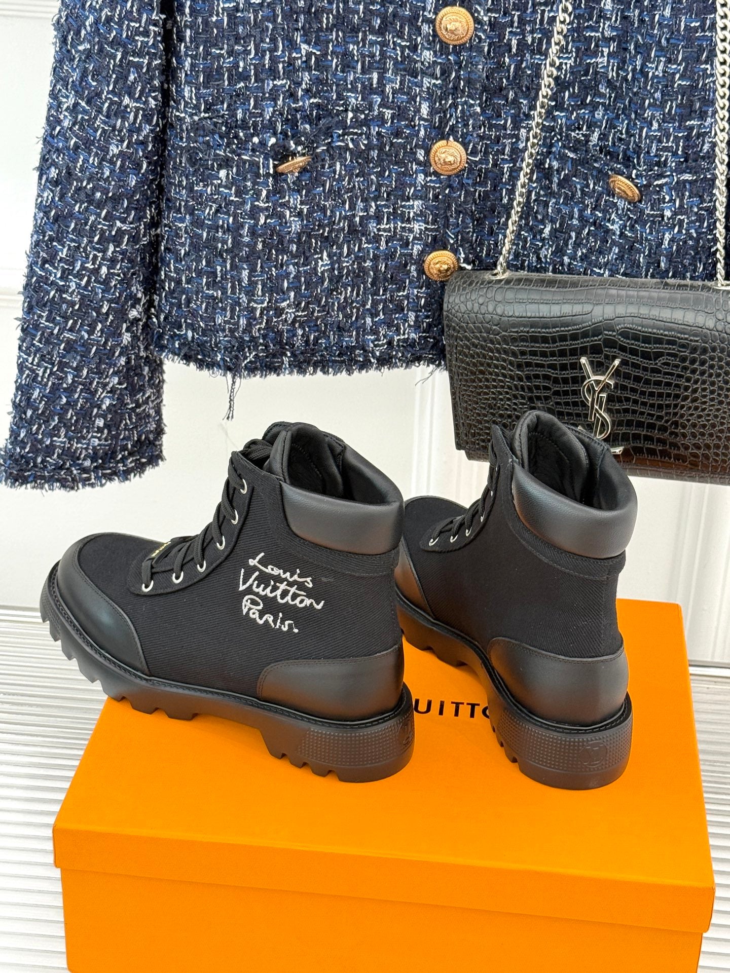Black mid-top lace-up boots with side logo and rugged lug sole