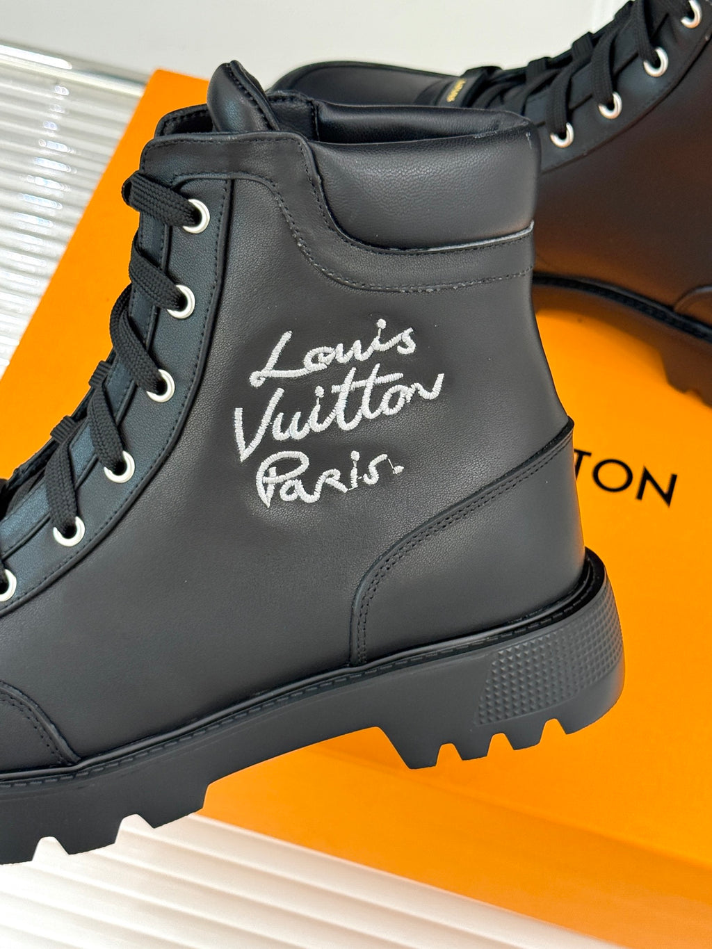 Black leather lace-up boot close-up with 'Louis Vuitton Paris' script