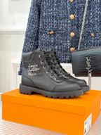 Black leather lace-up ankle boot with logo on side and chunky rubber sole