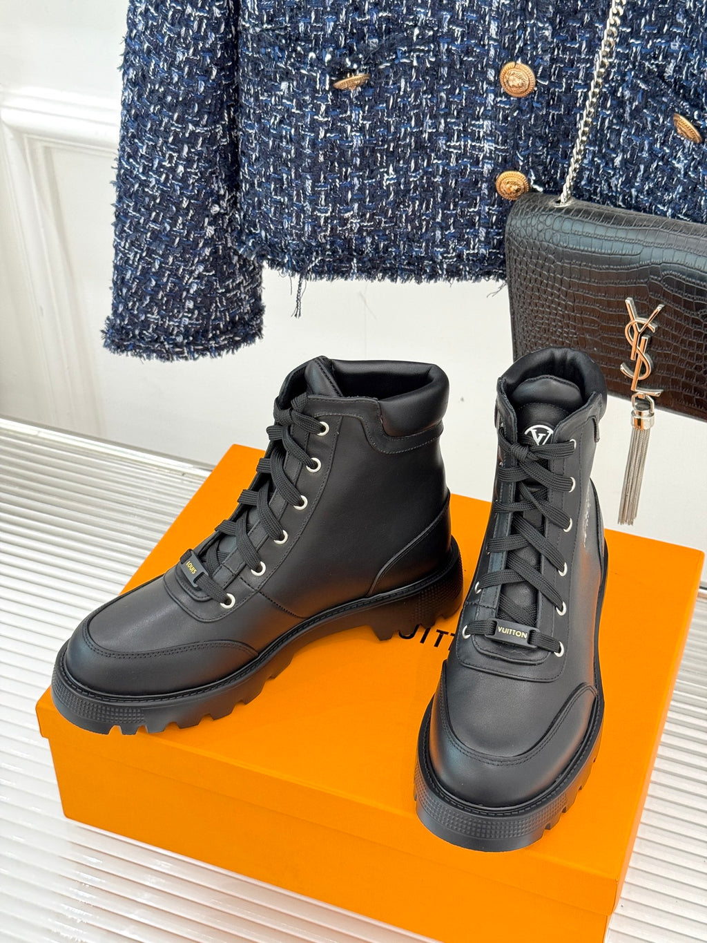 Pair of black lace-up ankle boots with thick tread and high shaft