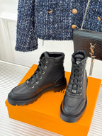 Pair of black lace-up ankle boots with thick tread and high shaft
