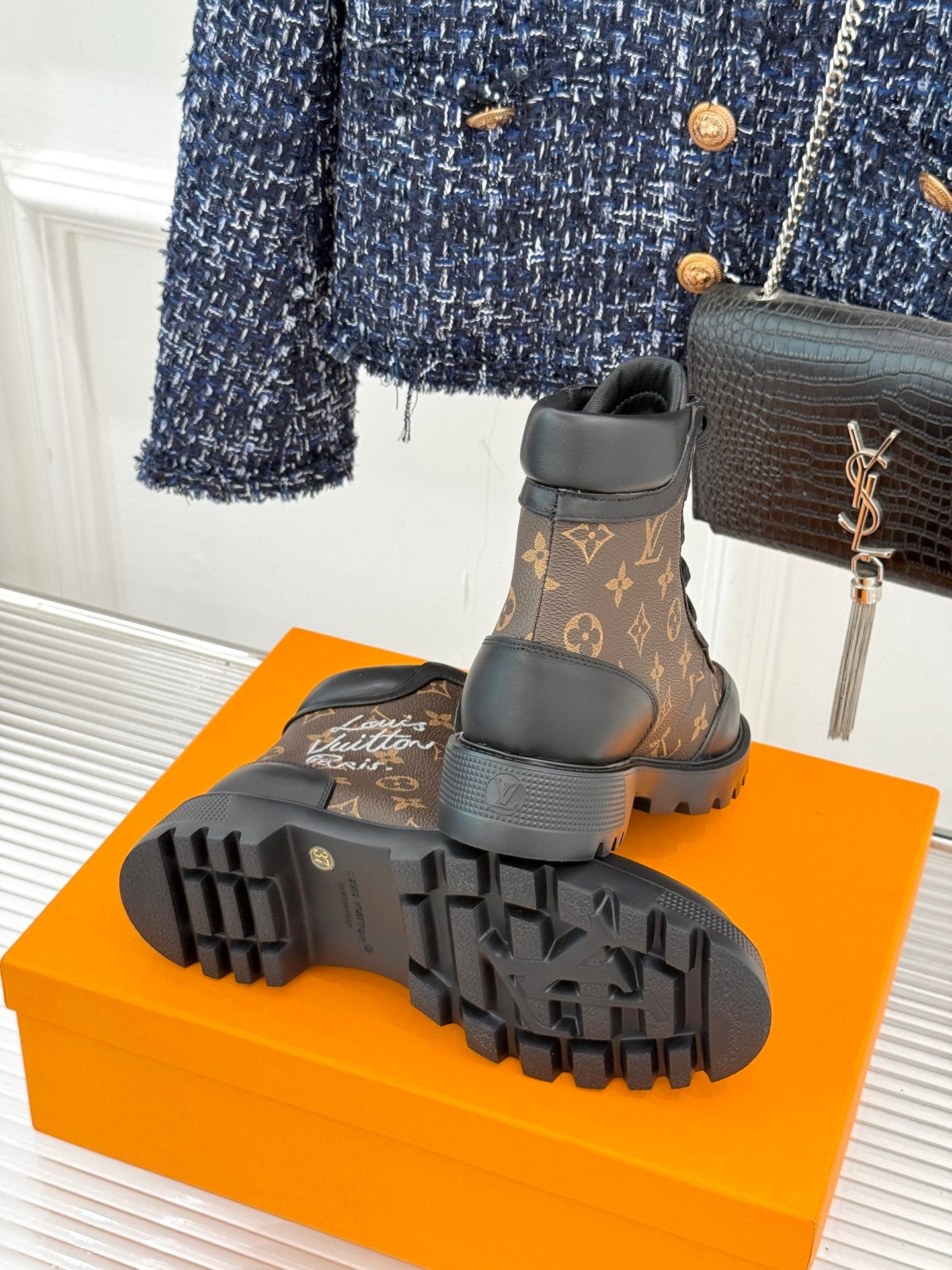 Outsole view monogram lace-up boots, chunky tread on black rubber sole
