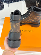 Heel view monogram lace-up boots, brown upper with black collar and textured rubber sole