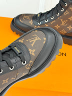 Side view monogram lace-up boots, brown upper with black trim and thick tread sole