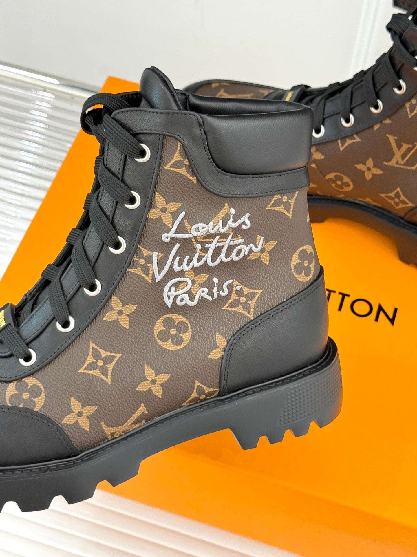 Close-up monogram lace-up boot, brown upper with black ankle panel and eyelet laces