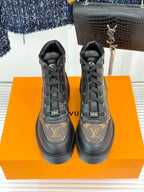 Pair of monogram lace-up boots, dark brown leather with black laces and treaded sole