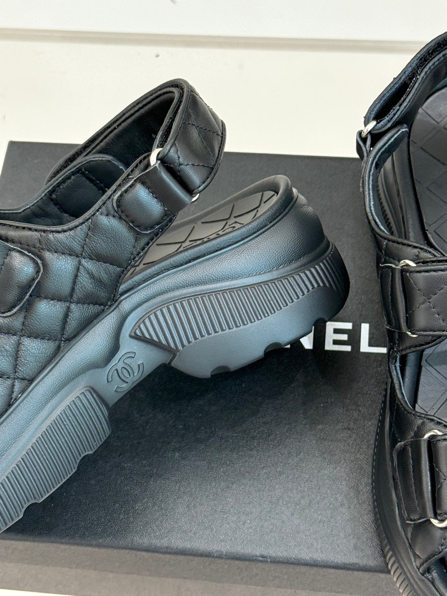 Chanel dark platform slide sandal showing textured sole and quilted strap