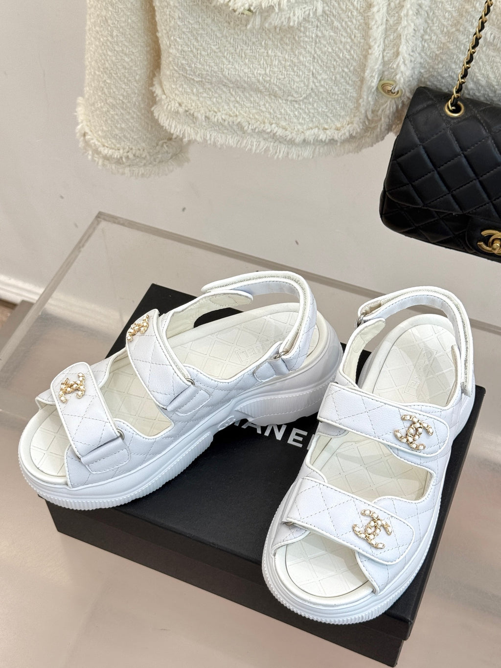 Chanel ladies white leather platform sandals with gold logo buckles on a black box