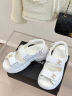 Chanel ladies white leather platform sandals with gold logo buckles on a black box