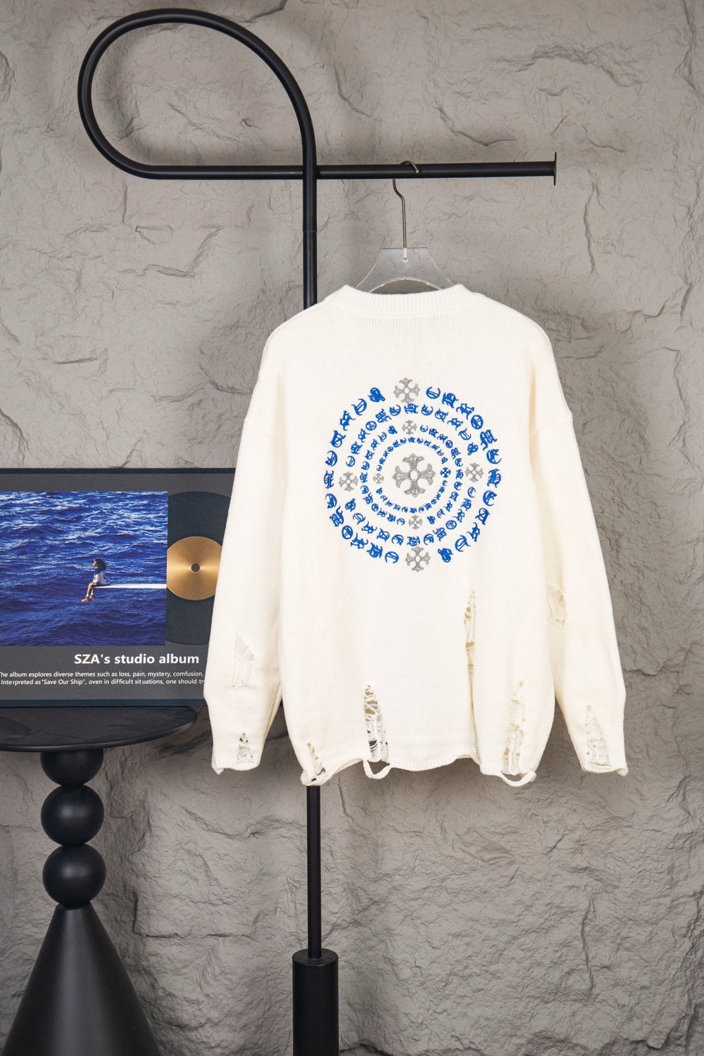 White long-sleeve knit sweater with large back circular blue graphic