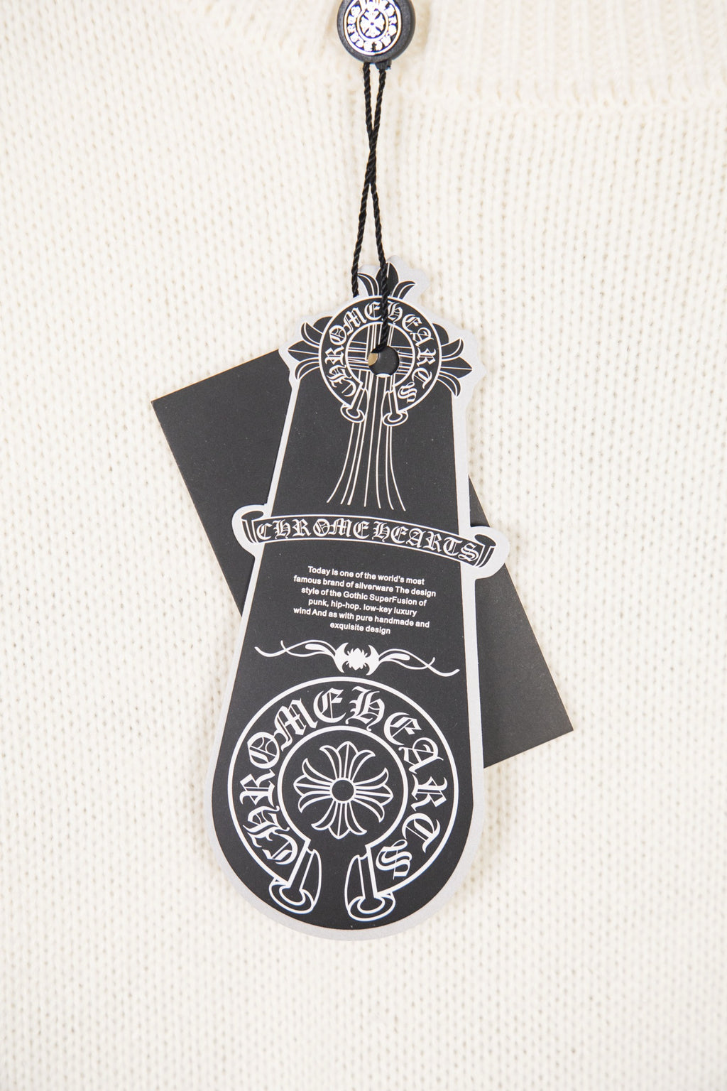 White knit sweater front tag graphic with ornate crest and text