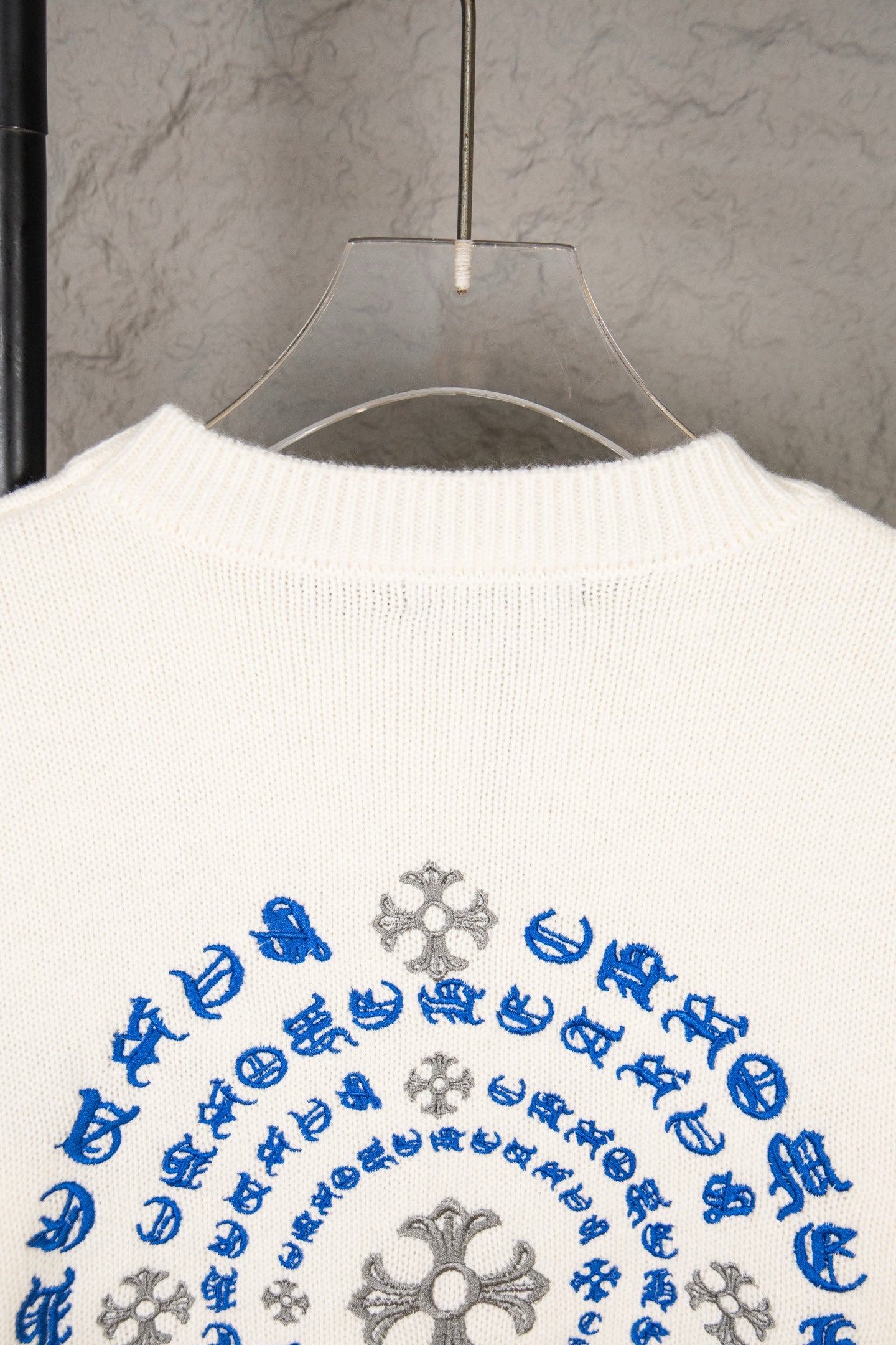 White knit sweater back with large circular blue and gray design