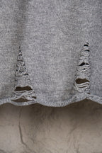 Grey knit sweater bottom hem with ruffled knitted edge detail