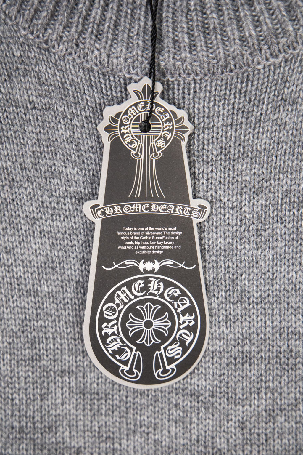 Grey knit sweater close-up with hanging white care label