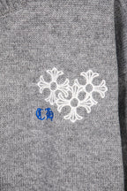 Grey knit sweater cuff with white and blue snowflake embroidery