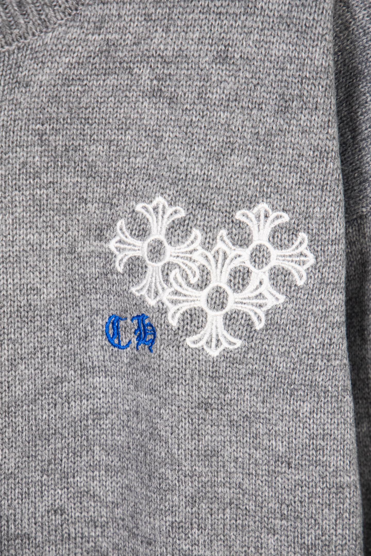 Grey knit sweater cuff with white and blue snowflake embroidery