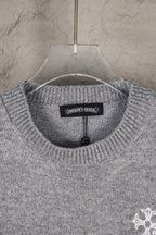 Grey knit sweater neckline with small chest logo detail