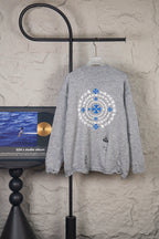 Grey knit sweater with large blue and white circular snowflake logo on back