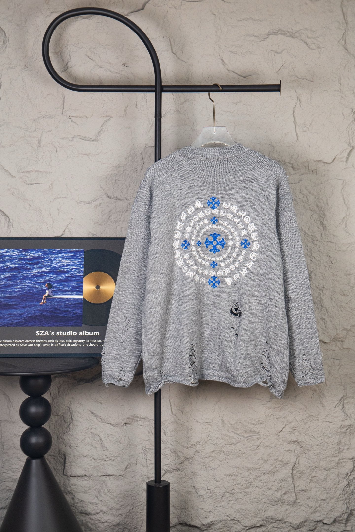 Grey knit sweater with large blue and white circular snowflake logo on back