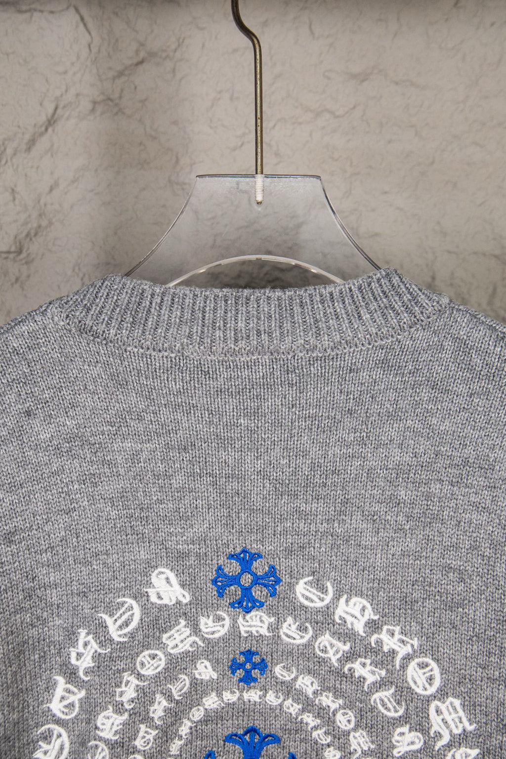 Grey knit sweater upper back with blue and white snowflake design