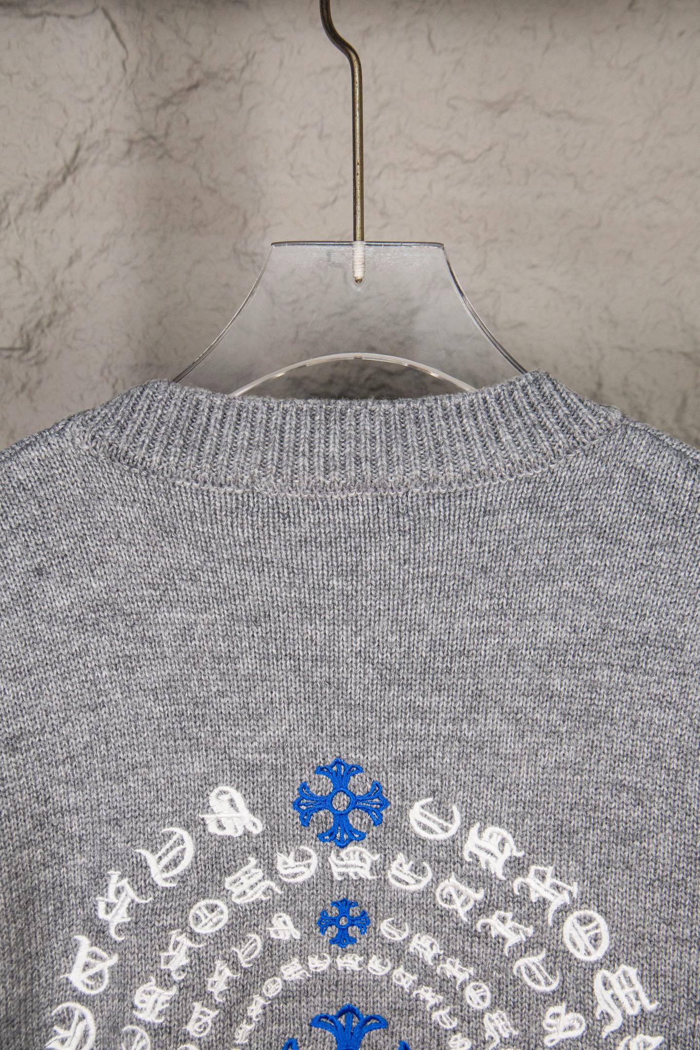 Grey knit sweater upper back with blue and white snowflake design