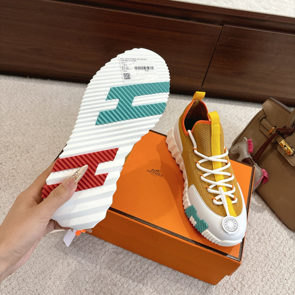 Hermes unisex sneakers outsole view, ridged white sole with teal and red stripes.