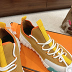 Hermes unisex sneakers close-up side, mustard and brown knit, white laces, teal sole.