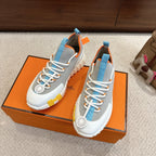 Pair of unisex luxury sneakers on box: grey mesh-look uppers, blue trim, white laces