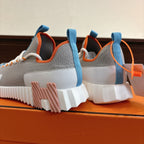 Rear view of unisex luxury sneakers: grey uppers with blue heel loops and chunky sole