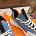Hermes unisex sneakers side view, blue denim upper, white laces, black pull tabs