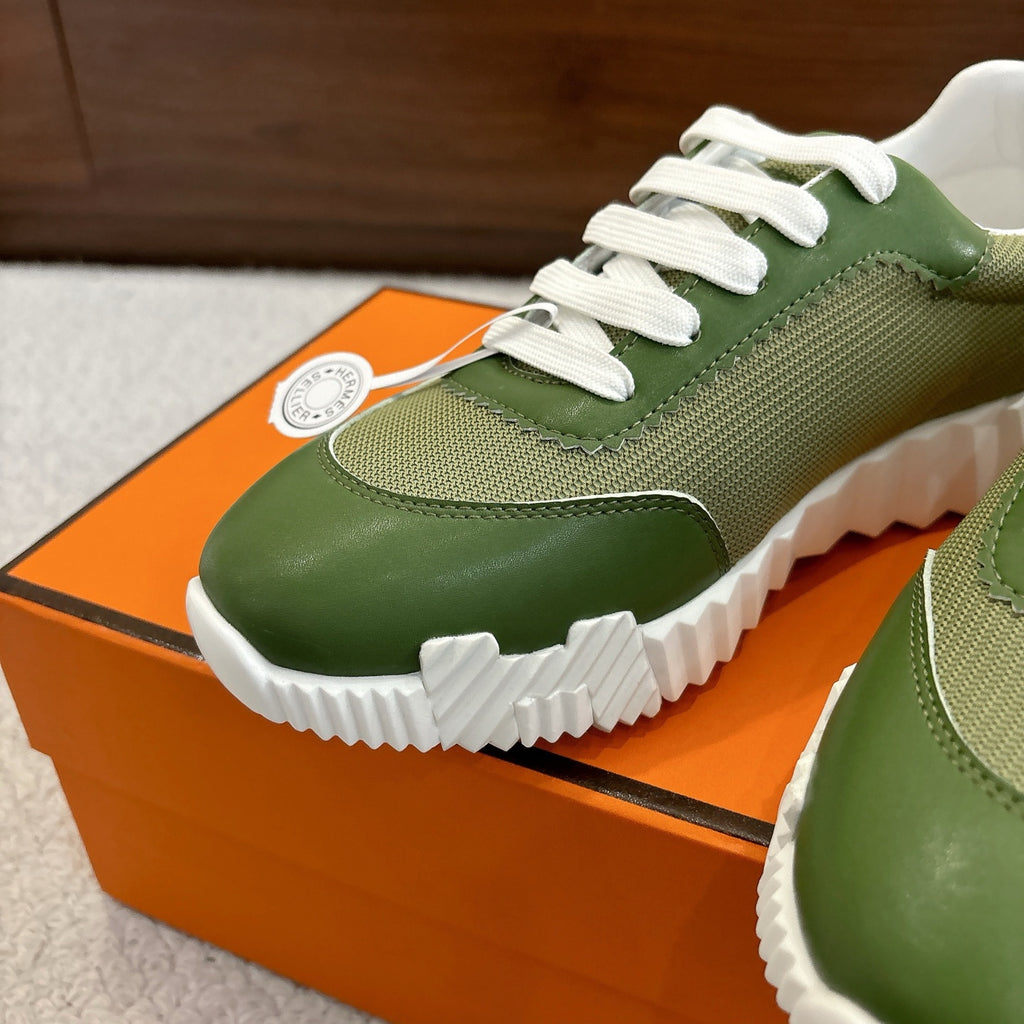 Close-up: green Hermes unisex sneaker with white laces and curved leather toe