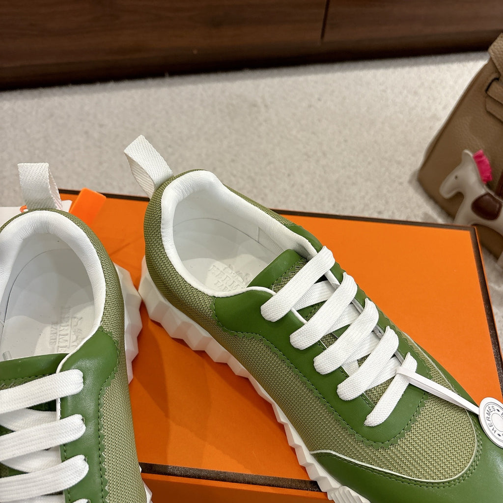 Green Hermes unisex sneaker view with white laces and logo coin detail