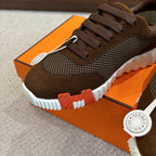 Brown mesh and suede sneakers with dark laces, textured white sole, close-up.