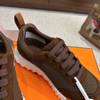 Brown mesh sneakers with dark laces and padded collar, close-up side view.