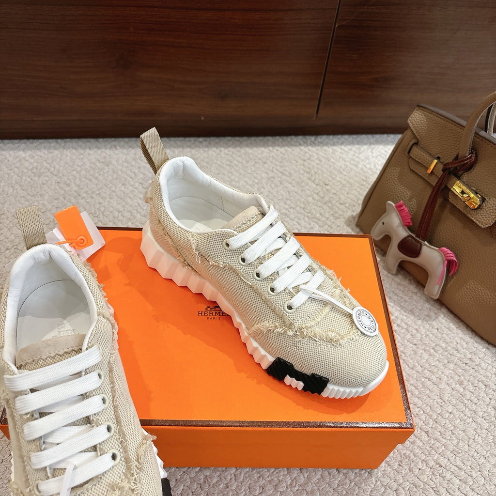 Hermes light beige sneakers with white laces, lace-up panel detail, and white tread sole