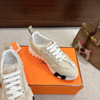 Hermes light beige sneakers with white laces, lace-up panel detail, and white tread sole