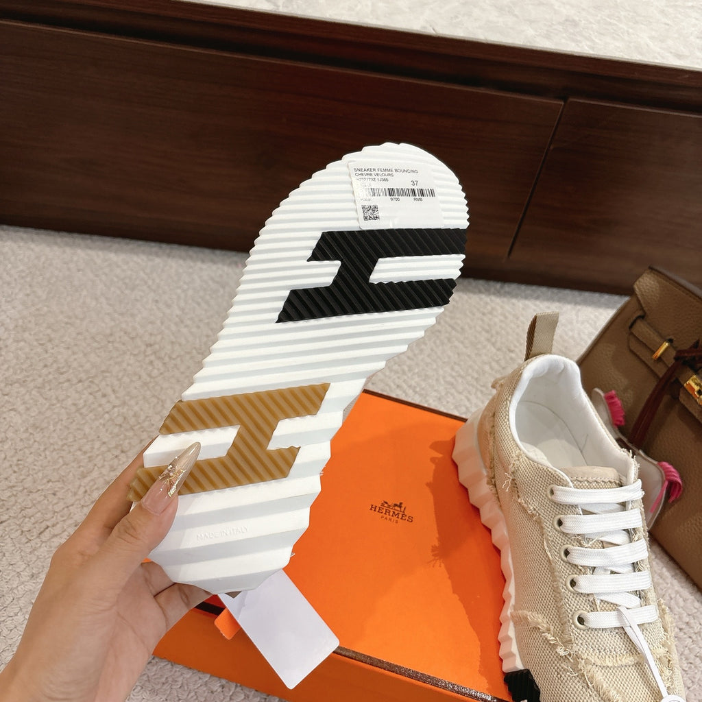 Hermes sneaker outsole view with black and white tread pattern; light beige upper