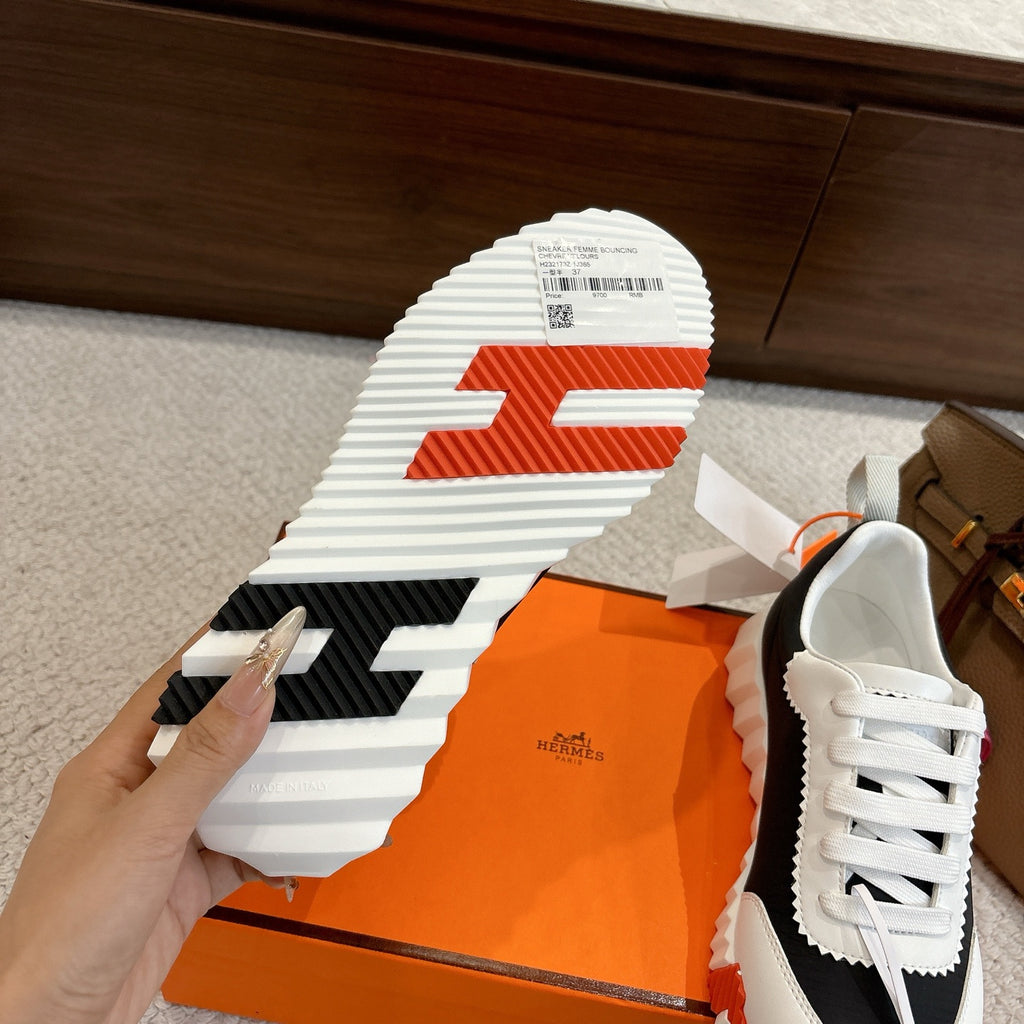 Hermes unisex sneaker outsole, striped traction with orange center and black heel insert.