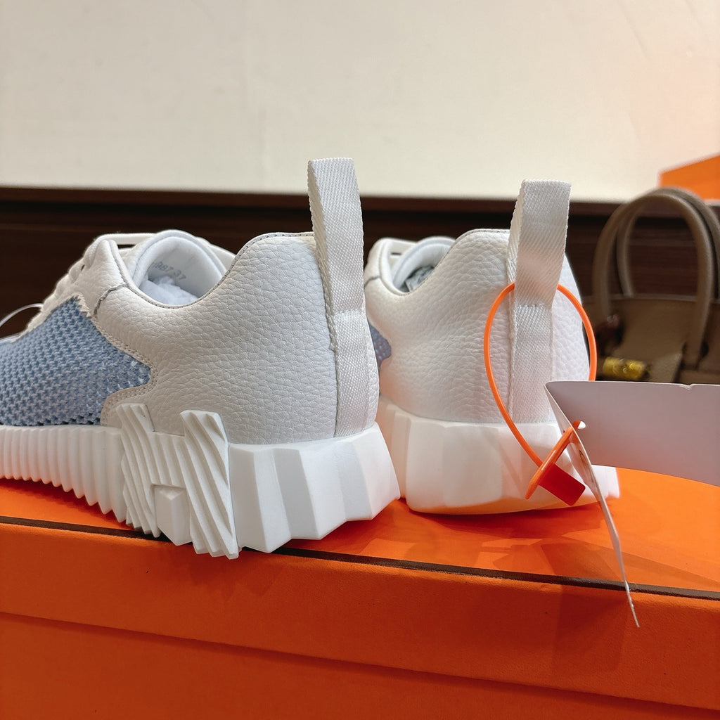 Hermes unisex luxury sneakers, rear view with white heel collar and light blue knit side panel.