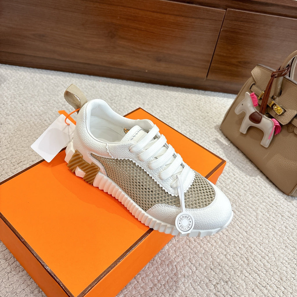 Hermes unisex sneakers, angled side view with white laces, tan mesh band and chunky sole.