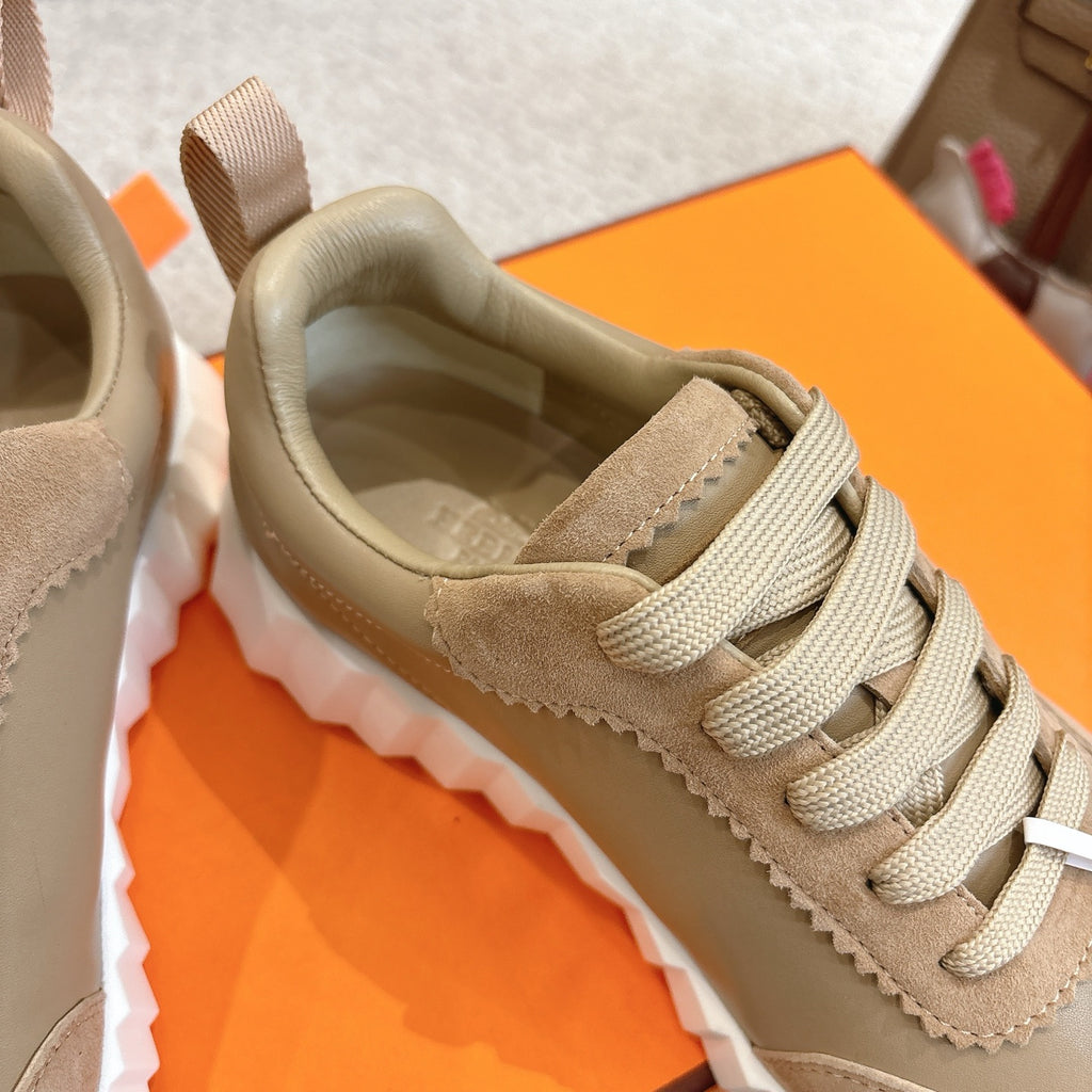 Unisex light tan sneaker close-up: lace-up, padded collar, and smooth suede panels.