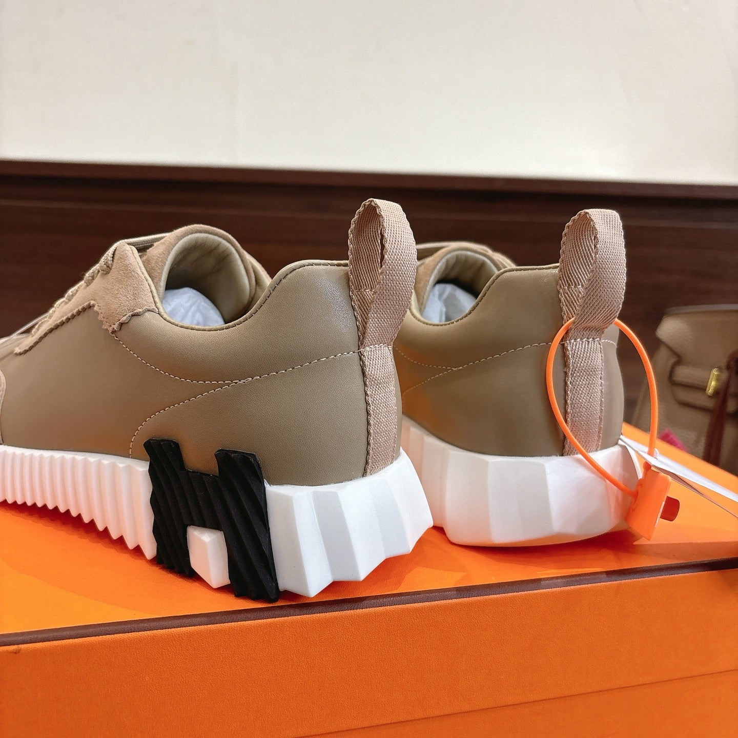 Unisex light tan sneakers heel view with black-and-white chunky sole tread.