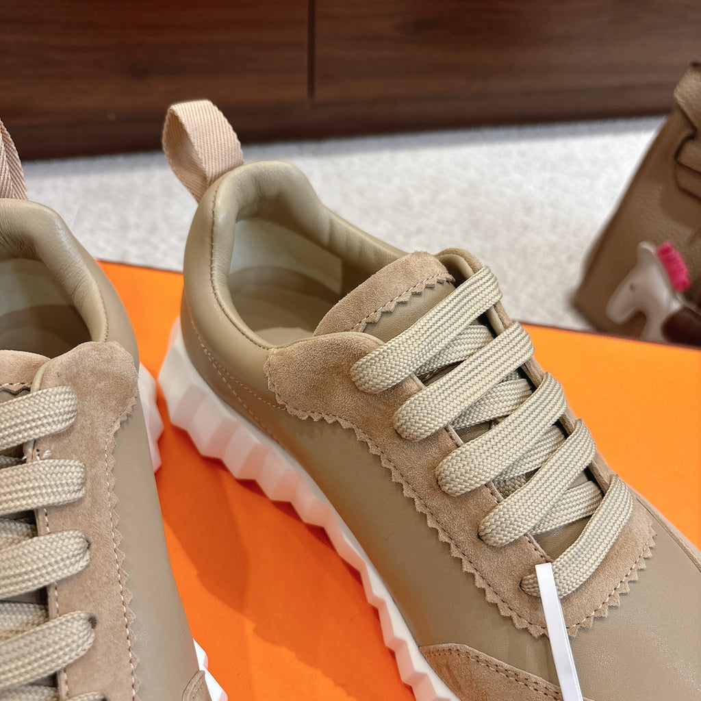 Beige suede sneakers with cream laces, textured side paneling, and white chunky sole