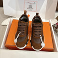 Hermes unisex sneakers in brown with lace-up suede panels and white ridged sole.