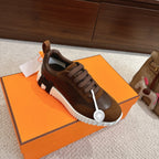 Hermes unisex sneakers, front angle, brown uppers, lace-up closure, white ridged platform sole.