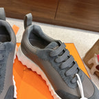 Gray lace-up sneaker with suede-like panels, scalloped edges, white sole